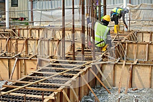 Group of construction workers fabricating ground beam formwork